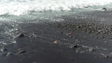 ocean waves washing off black beach surface, los gigantes, stable shot