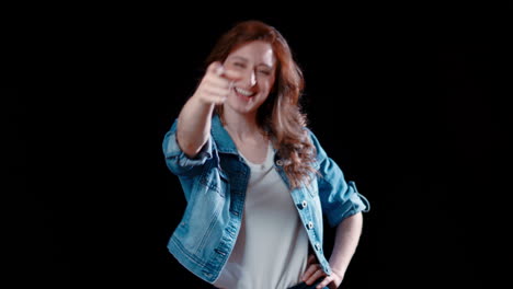 a young caucasian woman points and laughs at the camera