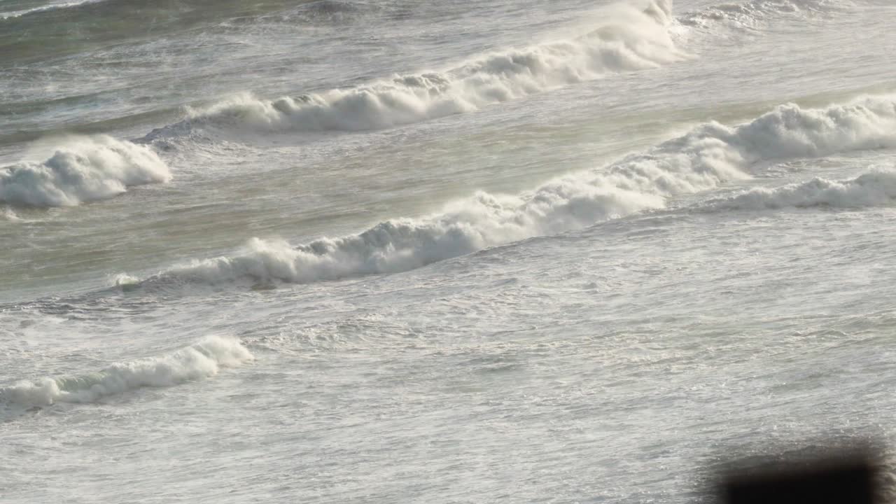 Dynamic waves crash along the Great Ocean Road, captured in natural lighting with a serene, rhythmic motion