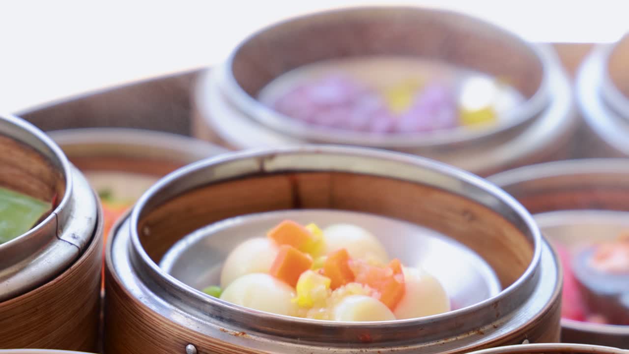 Close-up of colorful dim sum in bamboo baskets, showcasing vibrant ingredients under natural lighting in a restaurant setting