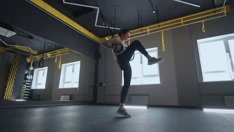 sporty woman doing trx exercises in the gym. women training with fitness straps in the gym. beautiful lady exercising her muscles sling or suspension straps.