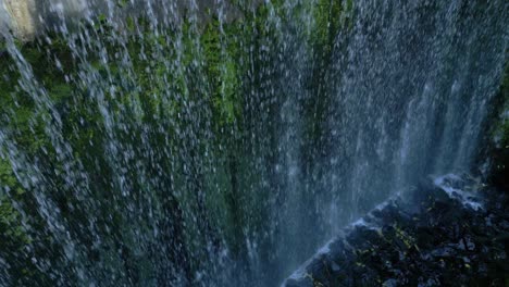 A-drone-shot-taken-close-to-the-edge-of-a-dam-that-is-lightly-overflowing-creating-a-small-waterfall