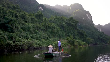 Toma-En-Cámara-Lenta-Del-Barco-Vietnamita-Tradicional-En-El-Paisaje-Del-Lago-Mágico,-Ninh-Binh