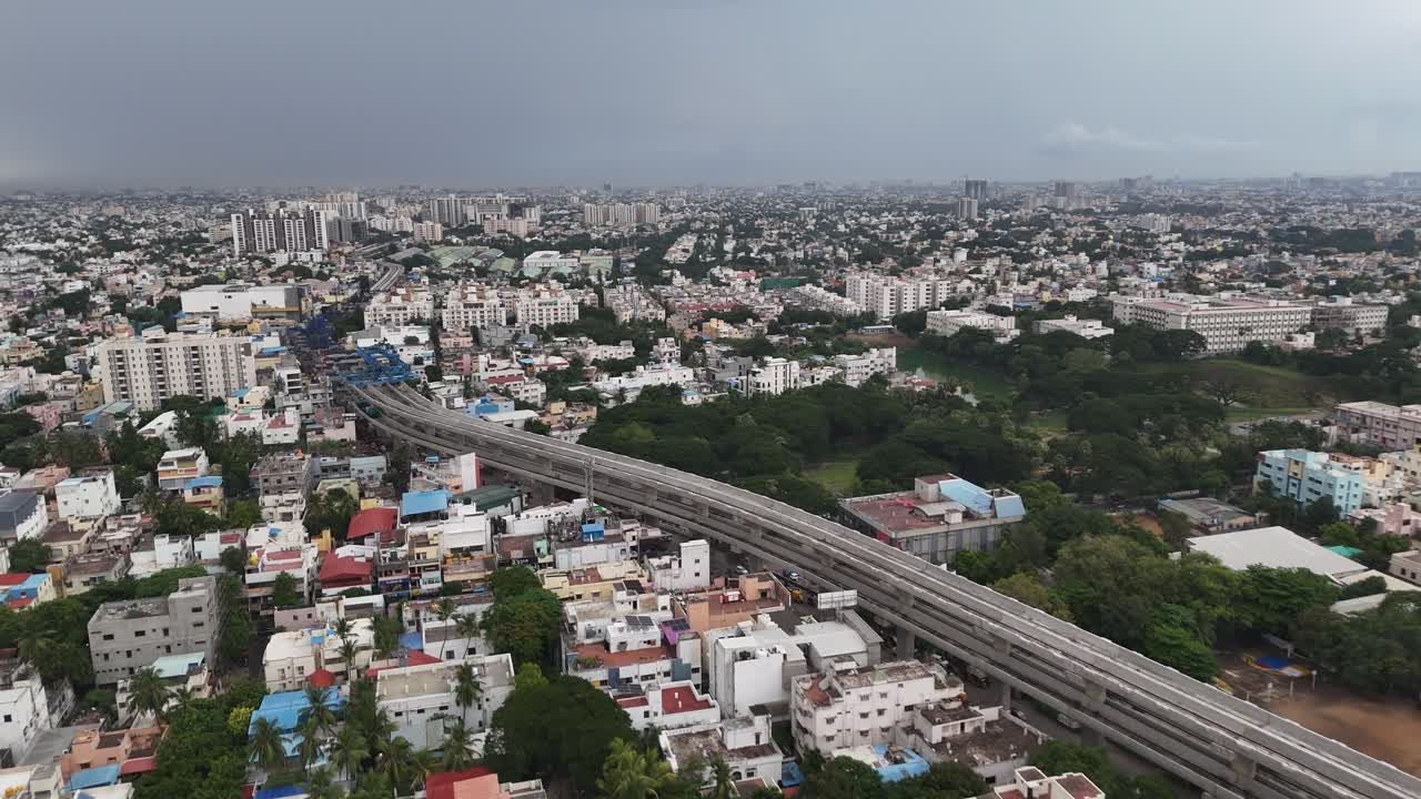Dynamic aerial footage of Chennai's urban infrastructure. elevated metro line construction, a rail depot, and busy roads, showcasing the city's push towards modern public transit and development