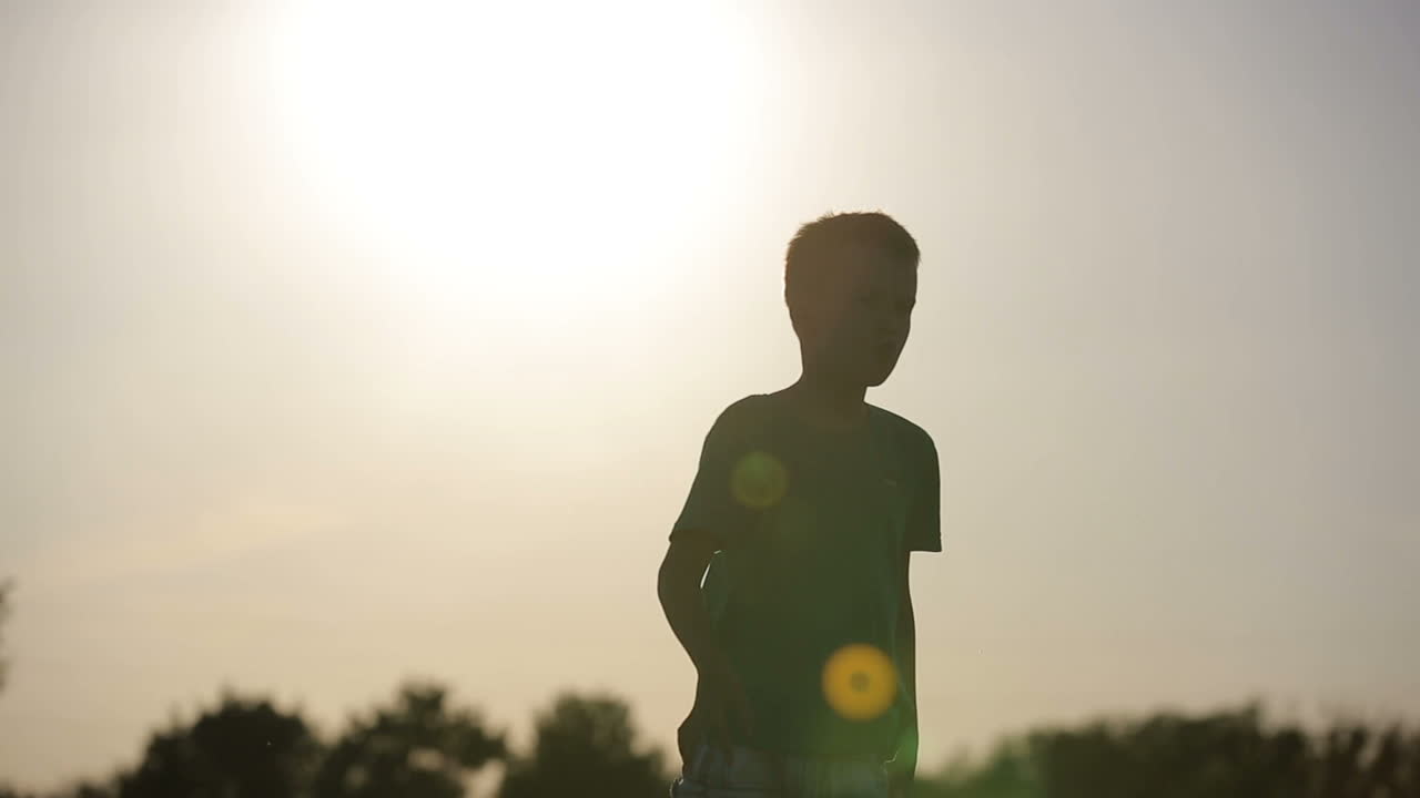Kid Playing With Plane. Smiling boy playing with flying paper airplane toy outdoors at sunset
