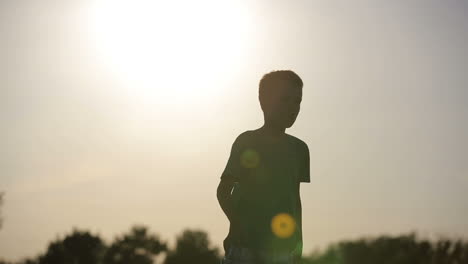 kid playing with plane. smiling boy playing with flying paper airplane toy outdoors at sunset