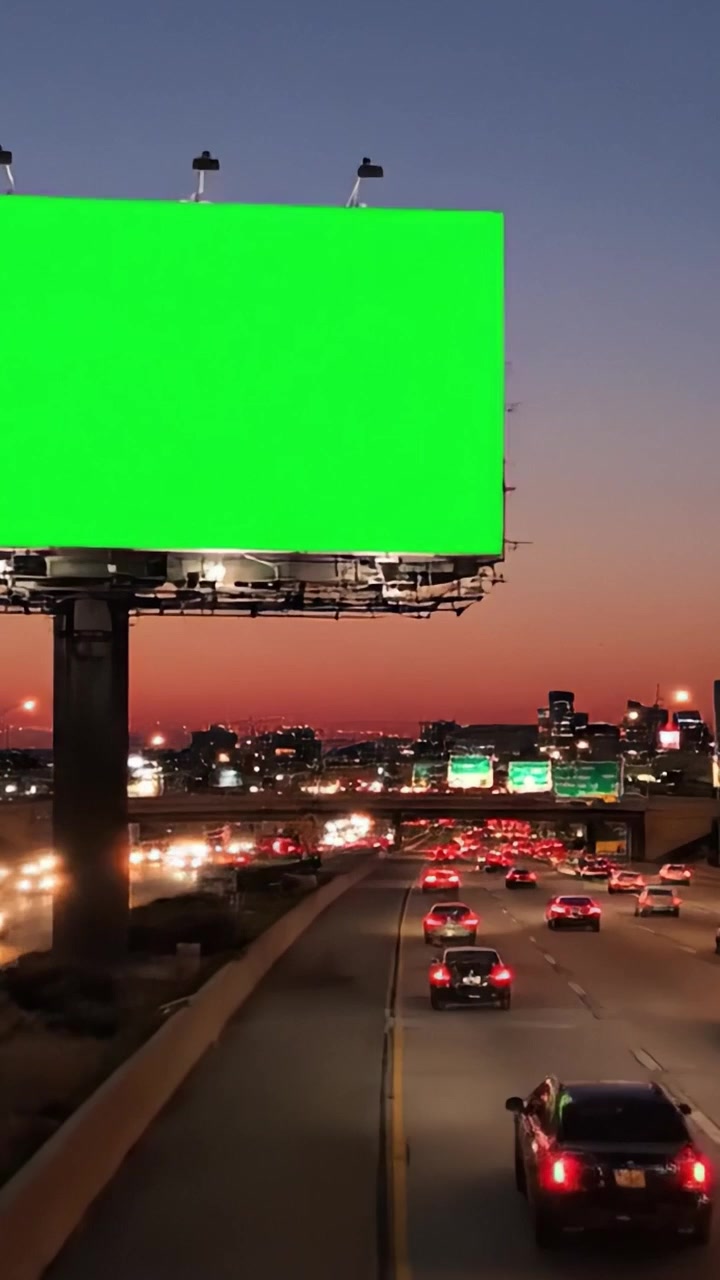 Doble perspectiva de una vibrante escena de carretera con una valla publicitaria verde iluminada en medio de las operaciones de tráfico vespertino en un bullicioso entorno urbano.