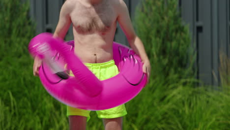 hombre con flamenco flotando en la piscina