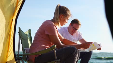 couple planning their camping trip on the beach