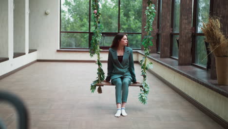 woman in green suit sitting on a swing