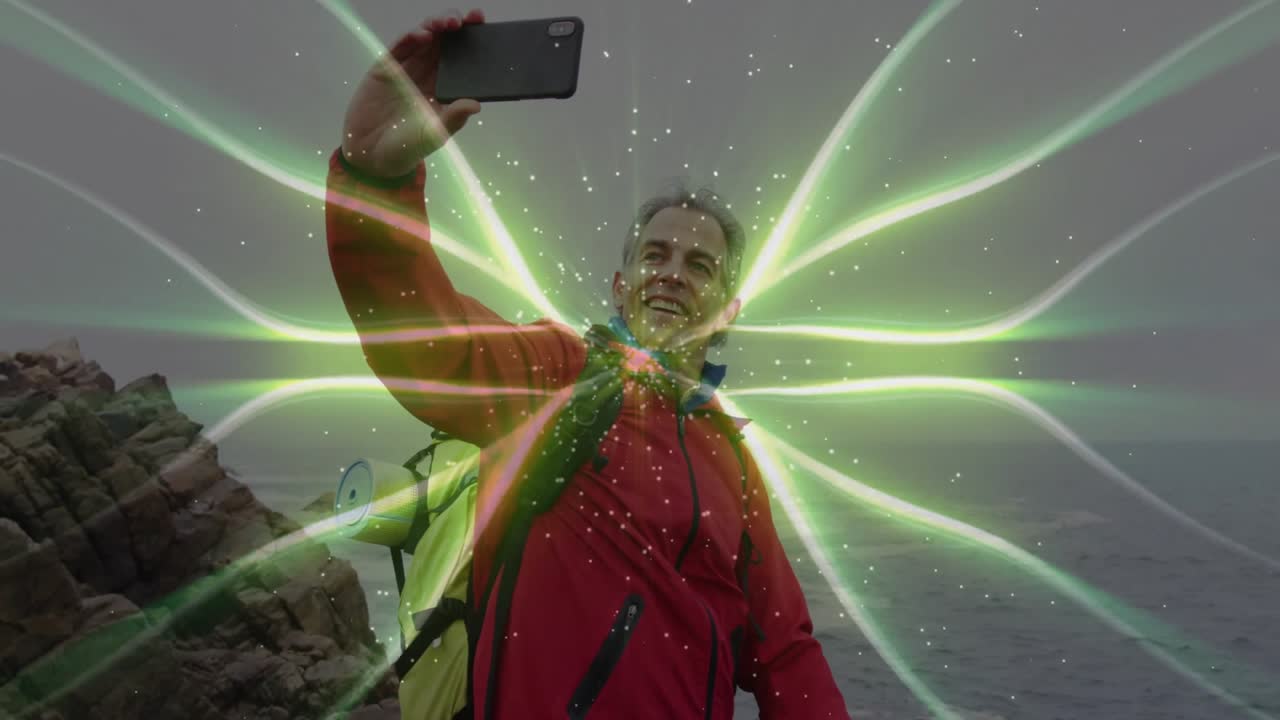 man holding smartphone on rocky coast, projecting green digital beams, showcasing tech concept
