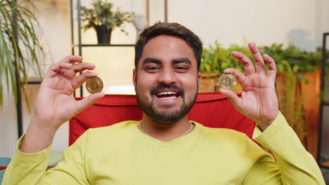 hombre indio comerciante de acciones ganando bitcoins monitoreo en línea operaciones comerciales minería mantener monedas btc