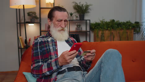 happy shopaholic senior old grandfather man making online payment with credit card, purchase, order