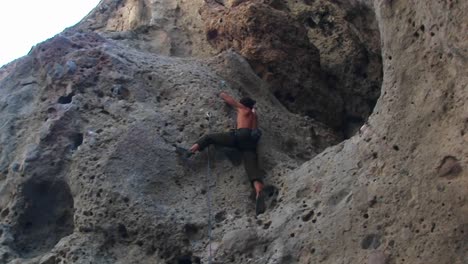 panright of a rock climber scaling a cliff wall