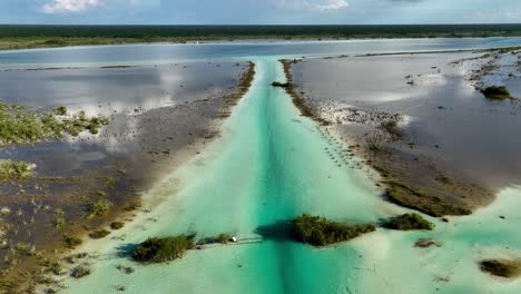 Vista-Aérea-Sobre-El-Lago-Bacalar-Y-La-Laguna-De-Siete-Colores,-En-El-Soleado-México---Levantamiento,-Disparo-De-Drones