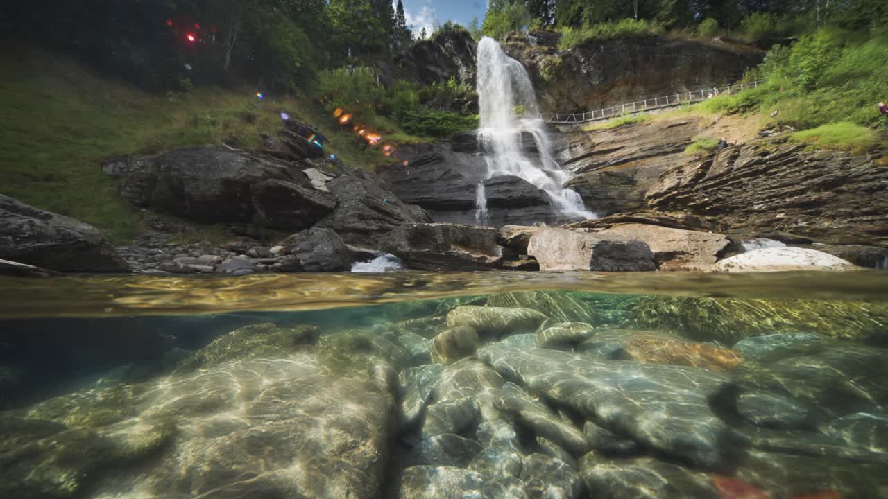 una escena tranquila con costas rocosas, agua cristalina y una cascada escénica