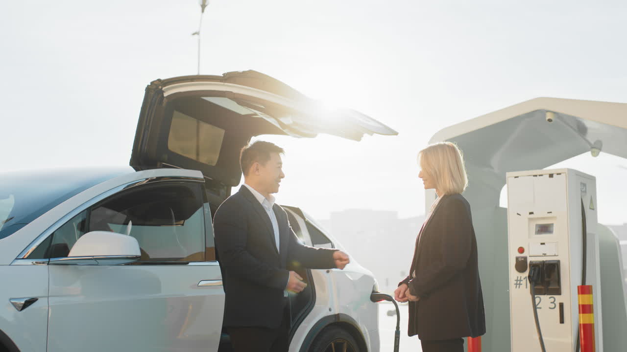 전기 차량을 충전하는 사업가