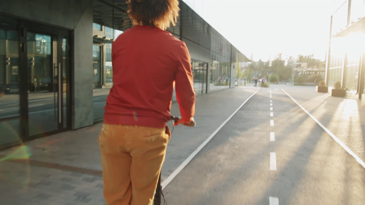 hombre montando un scooter eléctrico por la mañana