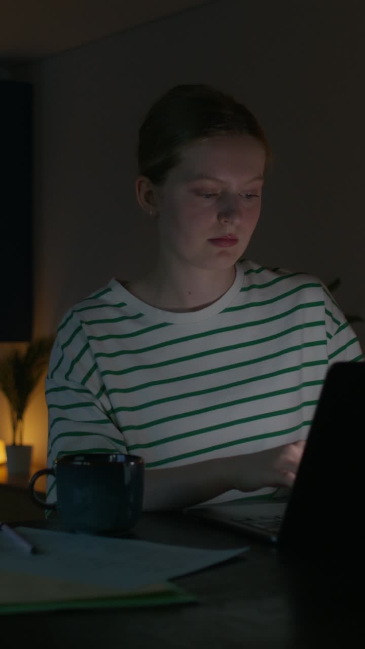 mujer joven trabajando tarde en la noche en una computadora portátil