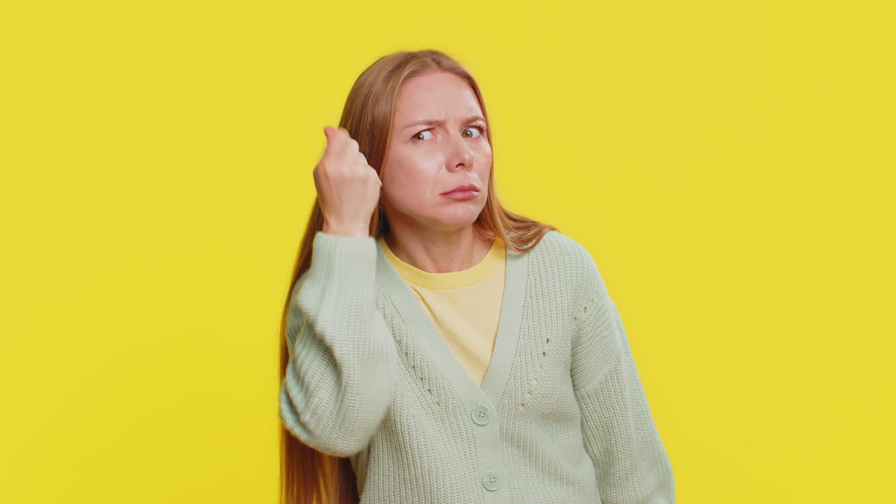Confused mature woman knocking locked door gesture asking who is at home feeling embarrassed no idea
