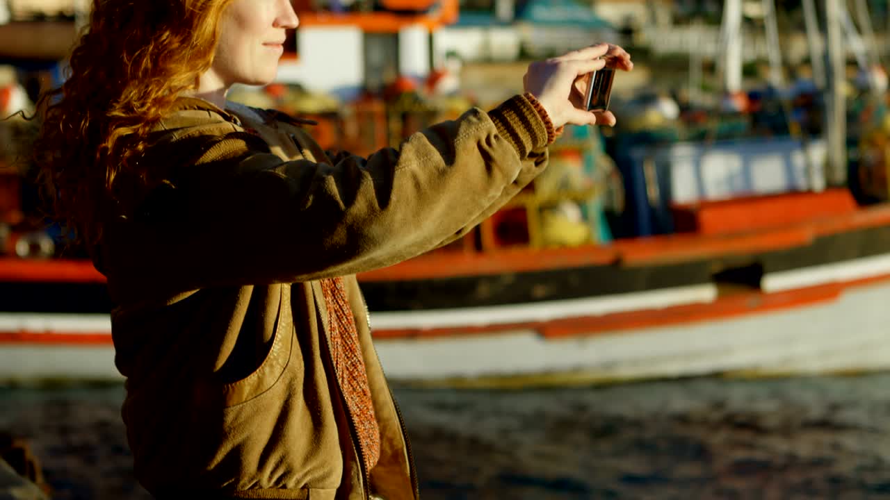 Woman clicking photos with mobile phone at dock 4k