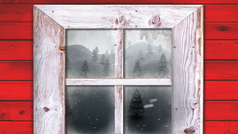 wooden window frame against snow falling over multiple trees on winter landscape