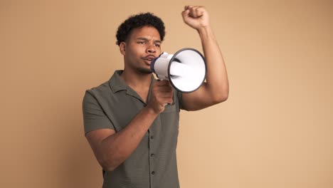 young man screaming on megaphone in beige studio