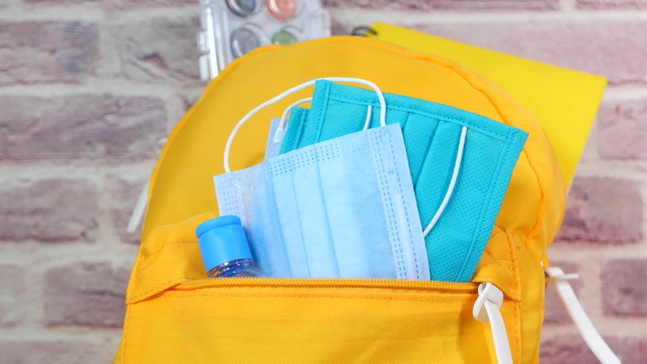 학교 용품과 얼굴 마스크와 손 소독제를 가지고 학교로 돌아갑니다.