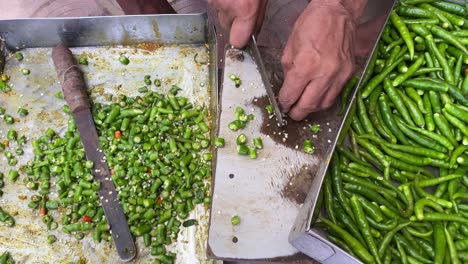 Nahaufnahme-Eines-Armen-Mannes,-Der-Am-Straßenrand-Dhaba-Grüne-Chilis-Hackt