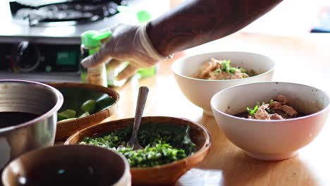 sequential preparation of noodle dishes in a kitchen