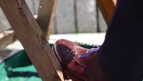 fourty percent speed clip of a man sawing wood at his wedding in a suit