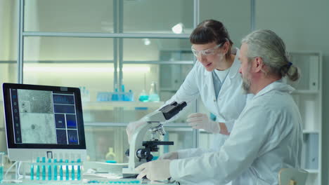 senior scientists working with young female colleague in lab