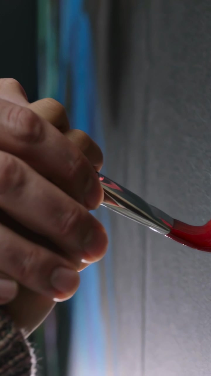 Vertical video: Guiding adult and kid hands making red mark with brush on canvas at home, teaching