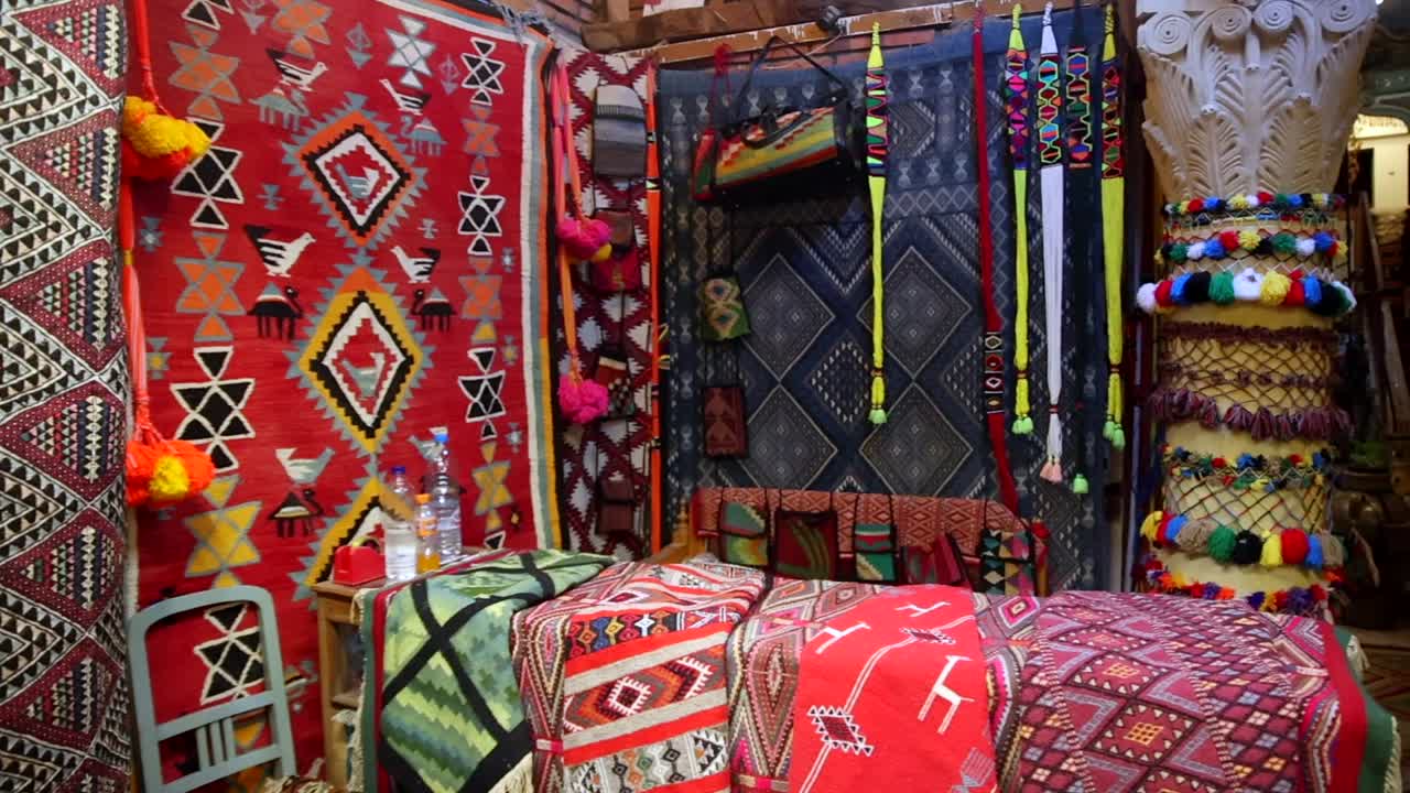 Colorful carpet and textiles stand in the souks streets, Tunisian traditional objects