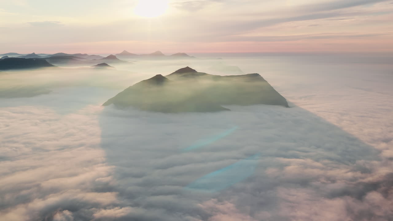 Majestic Mountain Peaks Emerging from a Sea of Clouds at Sunrise