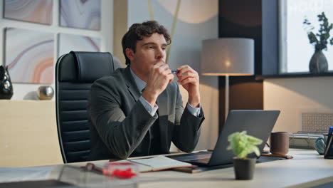 pensive businessman resting desk at cozy workplace. man taking break thinking