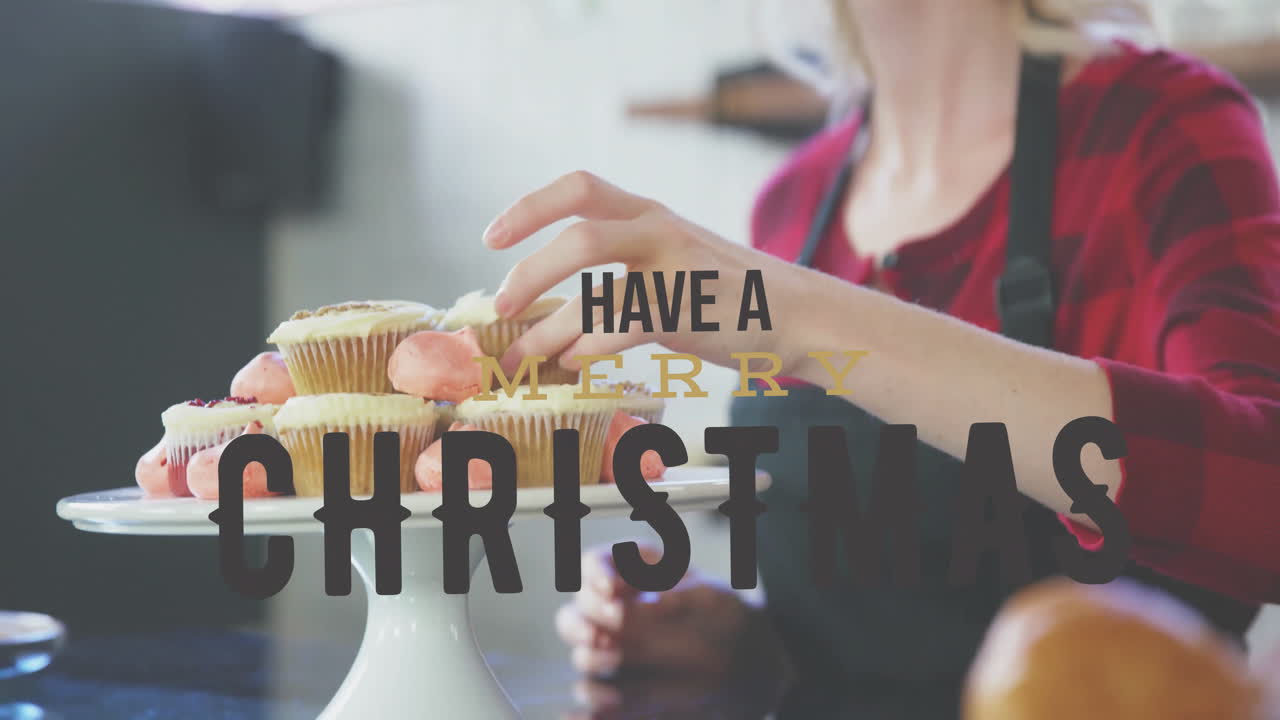 Arranging cupcakes on stand, woman adding animation with Merry Christmas text