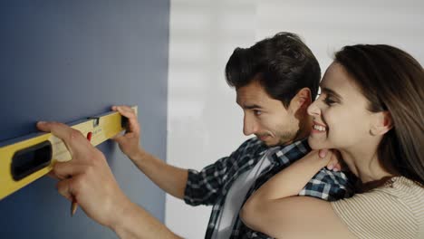 video de una pareja usando el nivel en la pared azul.
