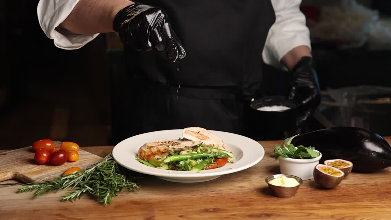Chef che Condisce un Piatto Gourmet Impiattato con Ingredienti Freschi