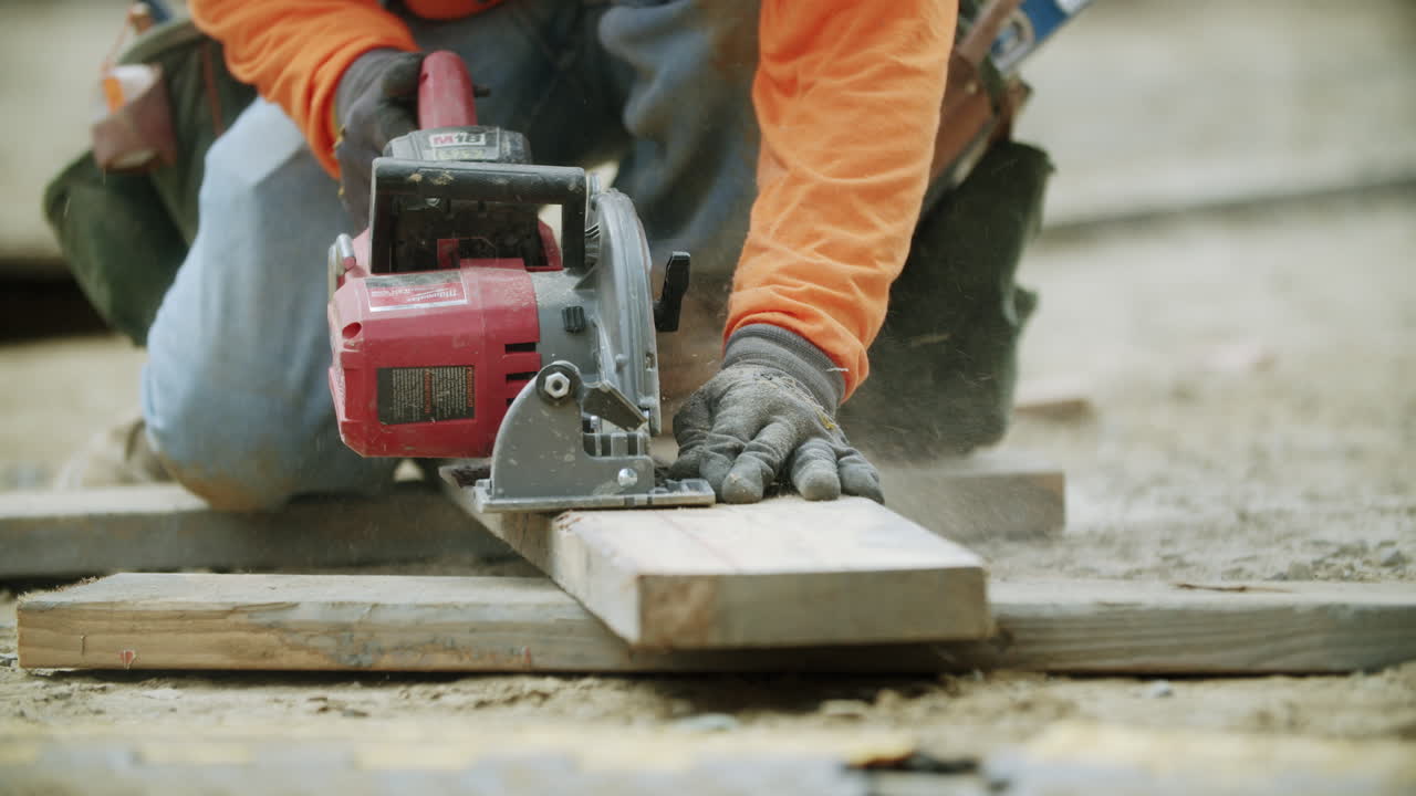 Construction worker using a circular saw to cut wood