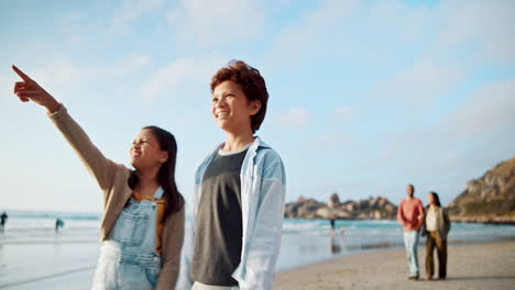 children, pointing and walking on beach