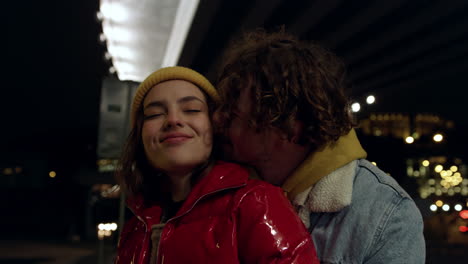 affectionate couple hugging under bridge. man and woman spending date in city.