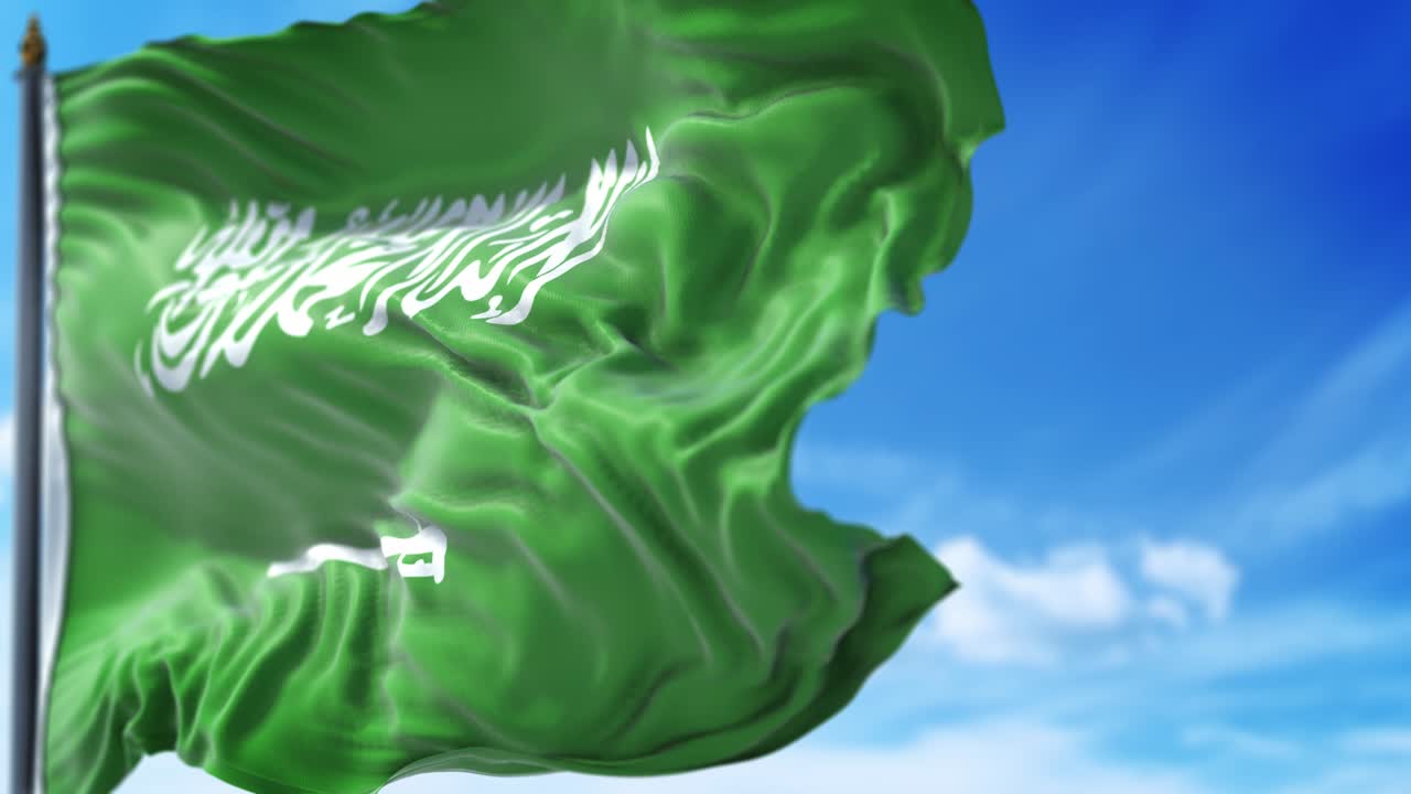 La bandiera dell'Arabia Saudita ondeggia lentamente contro il cielo blu