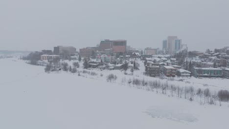 anchorage alaska, pull back reveal drone shot, cloudy snowy weather