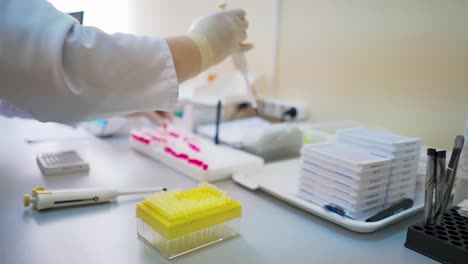 medical laboratory. female researcher working with test tubes on the table. hands of a lab specialist doing analysis with samples indoors.