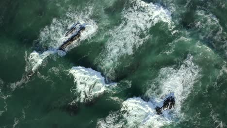 Top-down-drone-footage-of-crashing-waves-at-Zambujeira,-Portugal