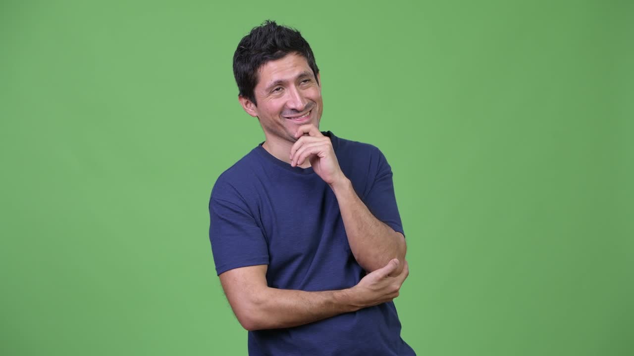 Hispanic man thinking against green background