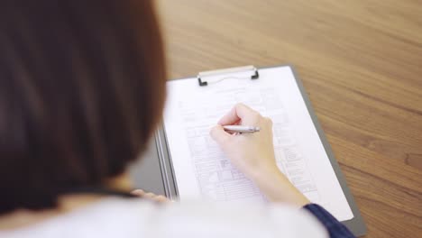 Detail of a female doctor filling a medical report
