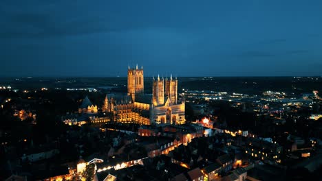 Aerial-drone-video-captures-the-renowned-Lincoln-Cathedral-in-Lincolnshire,-UK,-at-dusk,-showcasing-its-majestic-Gothic-architecture-with-illumination