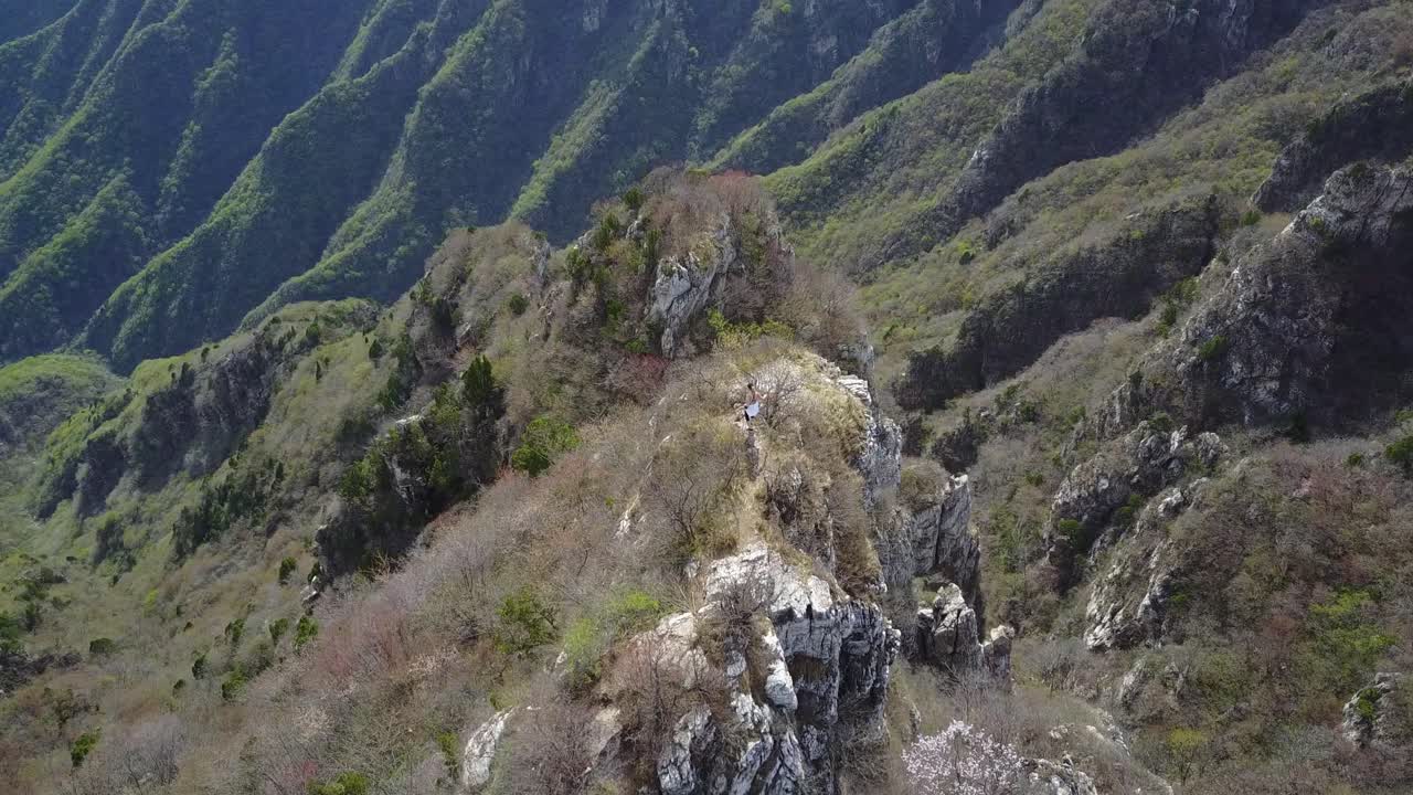 turista femenina camina por la precaria cima de una montaña dentada en china